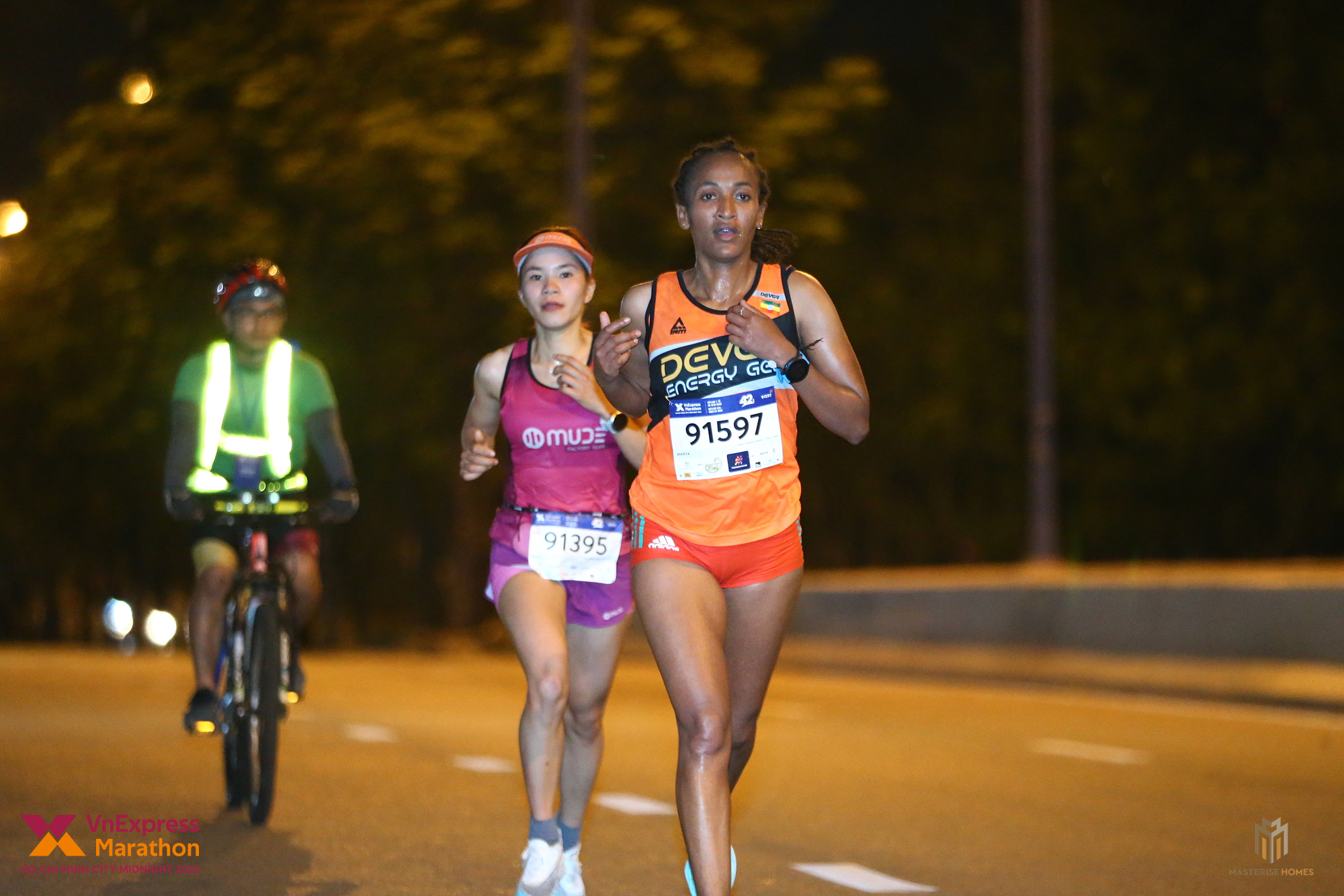 Hà Thị Hậu và runner người Kenya dẫn đầu cự ly 42km tại VM Ho Chi Minh City Midnight 2023. Ảnh: VM