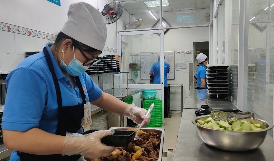 Nhân viên canteen Bệnh viện Hùng Vương chia phần ăn trước khi mang đến phòng cho bệnh nhân. Ảnh:Mỹ Ý